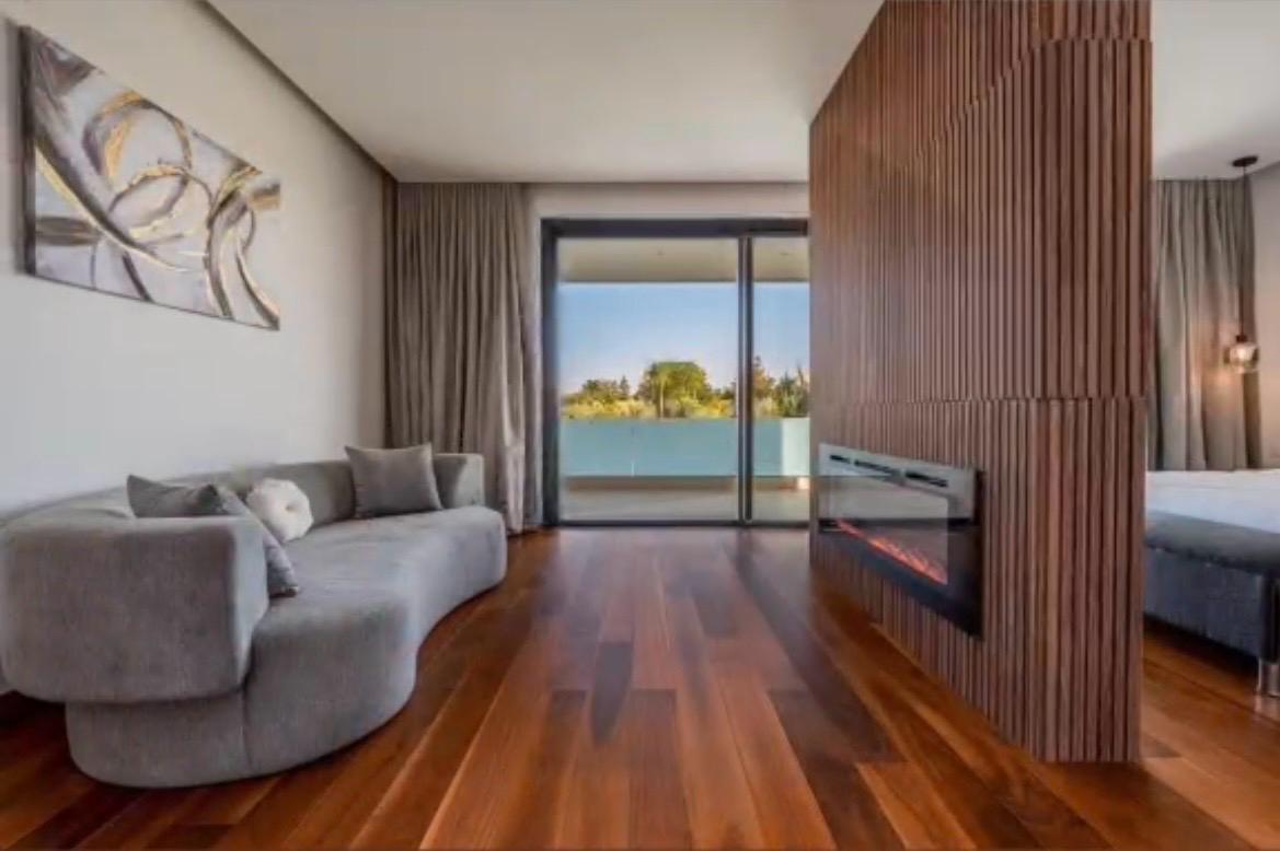 Second living room with linear fireplace and walnut-clad wall at The Royal VVIP