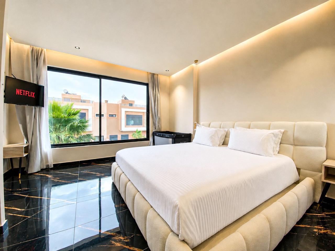 Master bedroom with bouclé bed and palm views at The Majorelle