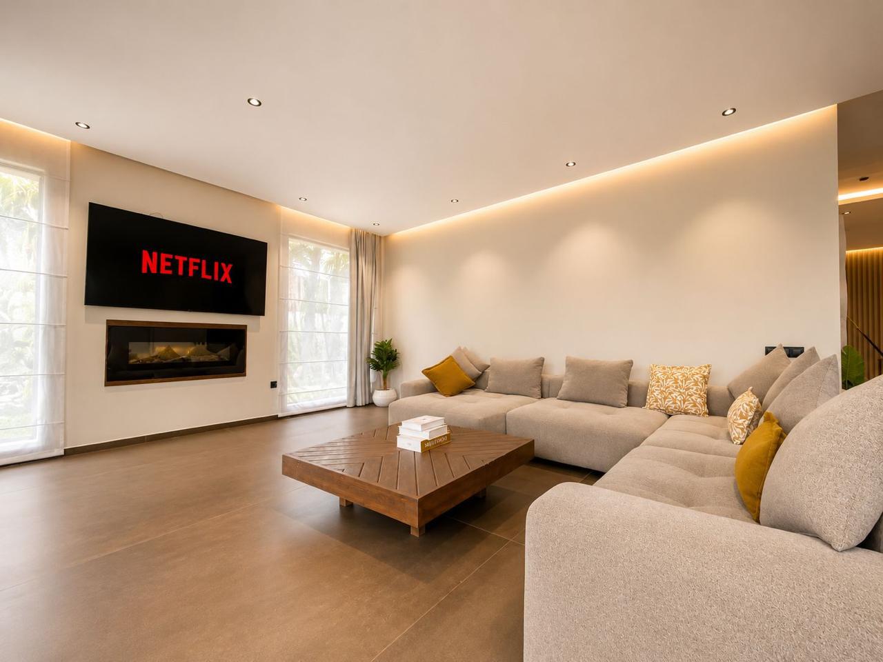 Living room with linear fireplace, smart TV and deep sectional sofa at The Majorelle