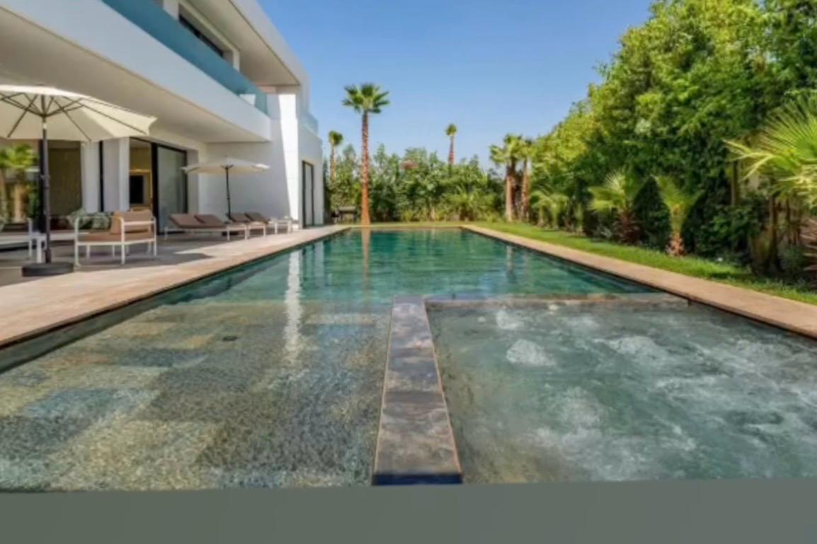 Long private pool with sun loungers and palm garden at The Royal VVIP