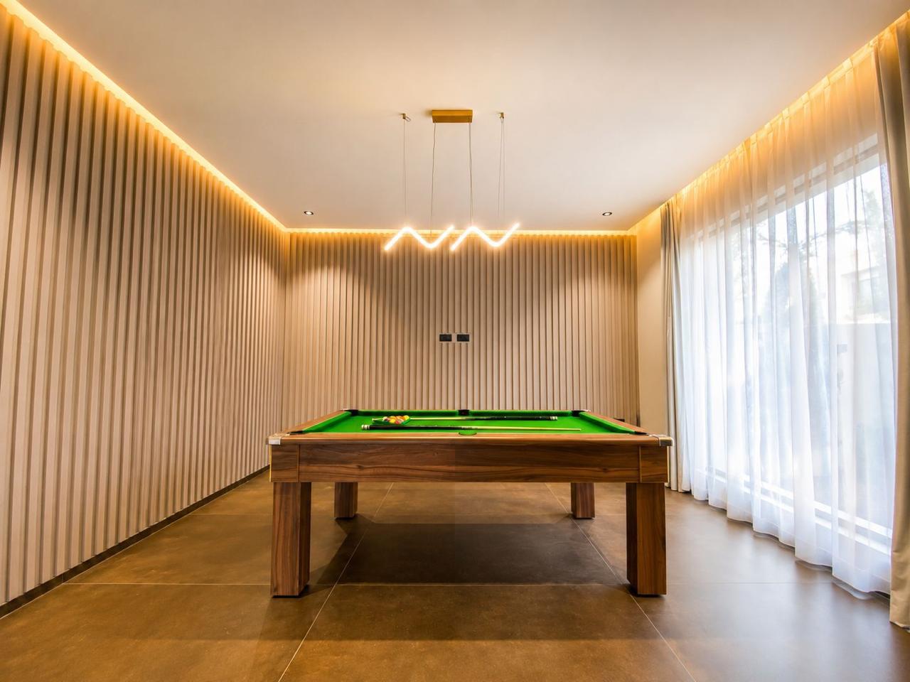 Games lounge with full-size pool table and fluted walls at The Majorelle
