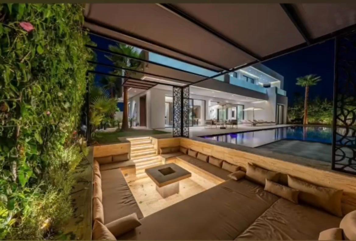 Sunken outdoor lounge and illuminated pool at night at The Royal VVIP