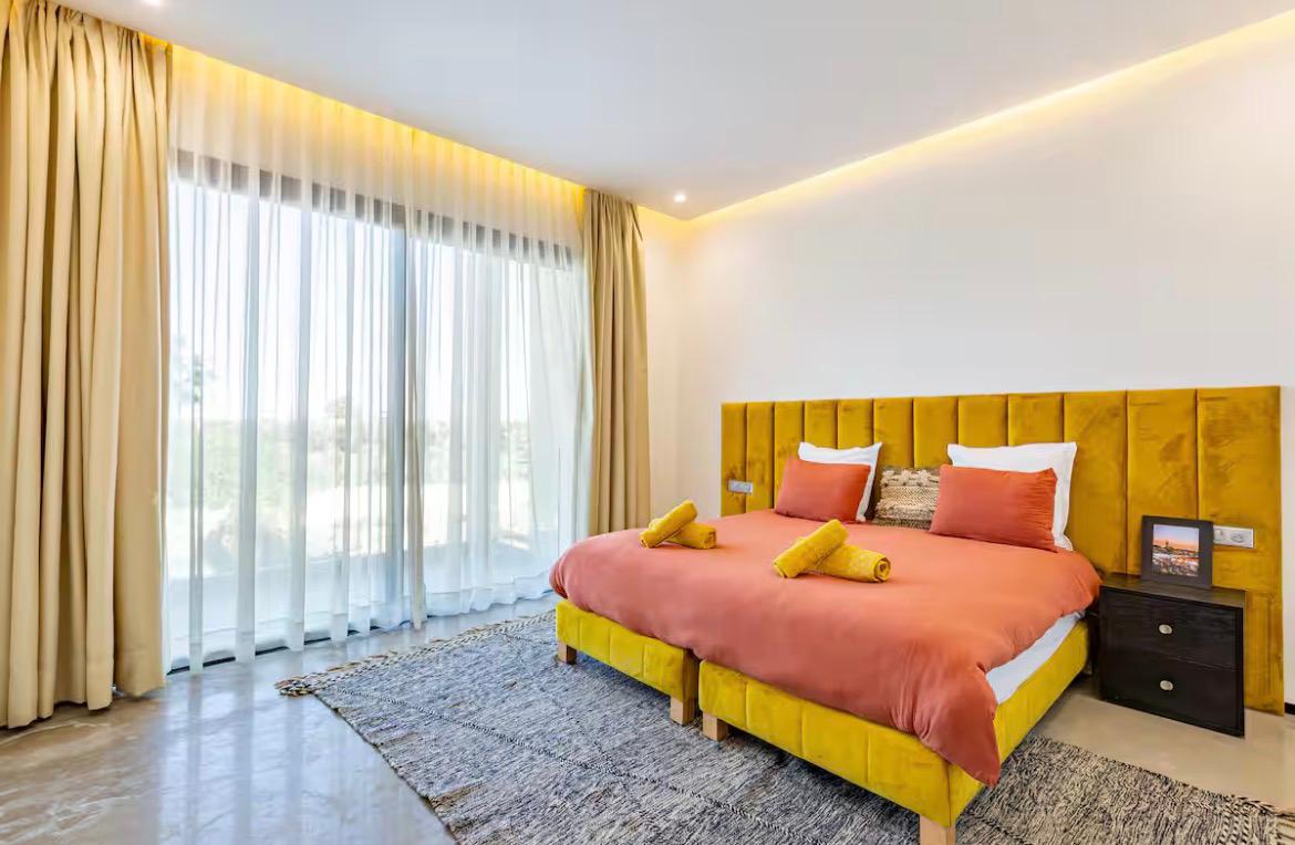 Master suite with velvet headboard and garden terrace at The Palm